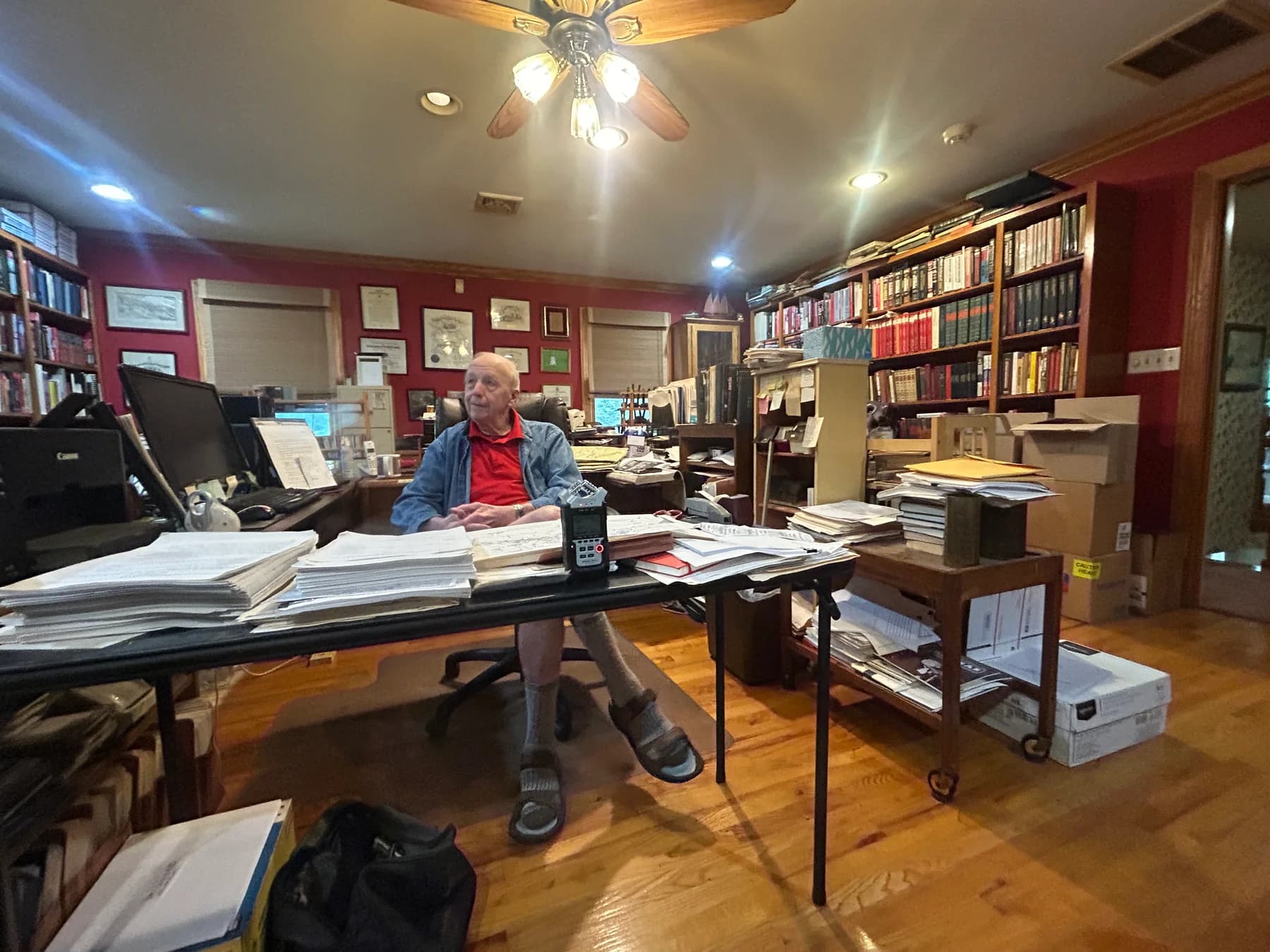 David Glantz seated at his desk, surrounded by books and research papers.